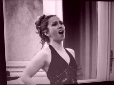 Rose-tinted black and white image of Ferzan singing